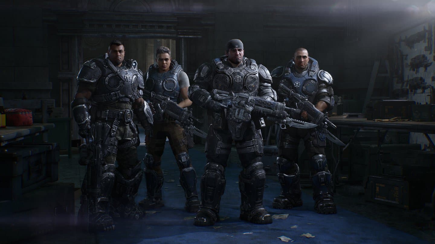Four soldiers in armor stand side by side in a dim armory, rifles in hand.