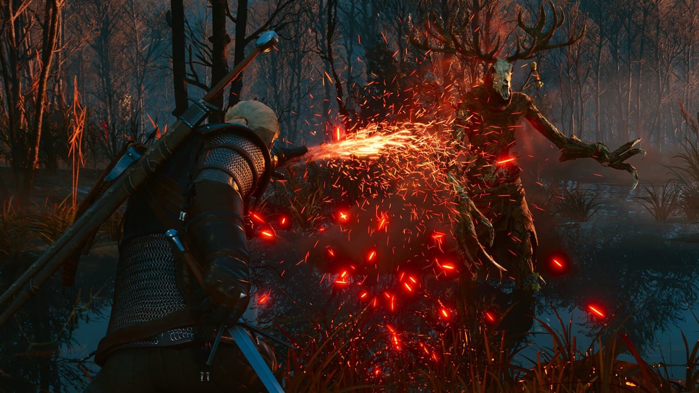 Geralt, his back to the camera, throws a jet of fire at a tall creature with antlers and a skull face in a dark forest.